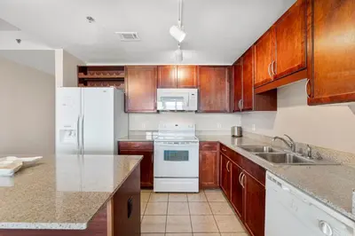 a kitchen with wooden cabinets and white appliances at Laketown Wharf #0932 in Panama City Beach