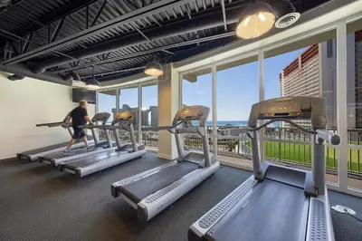 a man walking on treadmill in a gym with windows at Laketown Wharf #0932 in Panama City Beach