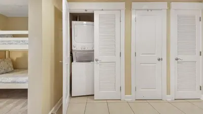 a laundry room with a refrigerator and a washer and dryer at Grand Panama #1-1705 in Panama City Beach