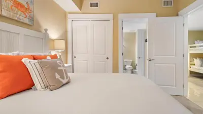a bedroom with a white bed with orange pillows at Grand Panama #1-1705 in Panama City Beach