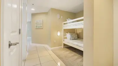 a room with two bunk beds and a hallway at Grand Panama #1-1705 in Panama City Beach
