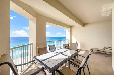a balcony with a table and chairs and the ocean at Grand Panama #1-1207 in Panama City Beach