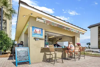 a group of people sitting at a restaurant at Grand Panama #1-1207 in Panama City Beach