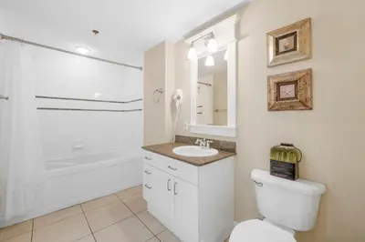 a bathroom with a toilet and a sink and a tub at Grand Panama #1-1001 in Panama City Beach