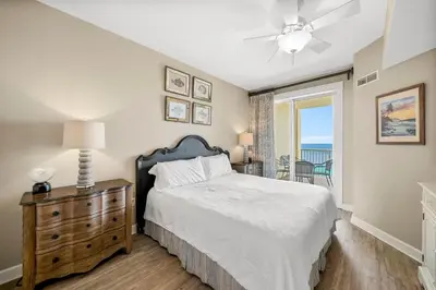 a bedroom with a bed and a dresser and a window at Grand Panama #1-1704 in Panama City Beach