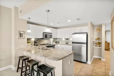 a kitchen with a large island with bar stools at Grand Panama #1-1704 in Panama City Beach