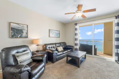 a living room with leather furniture and a view of the ocean at Grand Panama #1-1308 in Panama City Beach