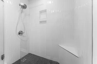 a white bathroom with a shower with a drain at Grand Panama #1-1308 in Panama City Beach