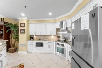 a kitchen with white cabinets and a refrigerator at Grand Panama #1-2201 in Panama City Beach