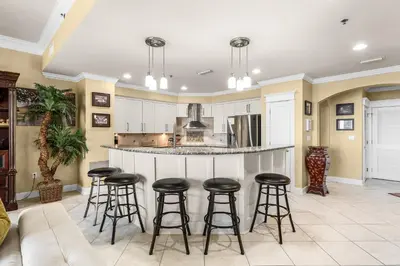 a large kitchen with a bar with stools at Grand Panama #1-2201 in Panama City Beach