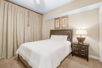 a bedroom with a bed and a table with a lamp at Grand Panama #1-0408 in Panama City Beach