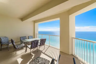 a balcony with a table and chairs and the ocean at Grand Panama #1-1903 in Panama City Beach