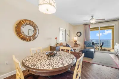 a dining room and living room with a table and chairs at Grand Panama #1-1903 in Panama City Beach