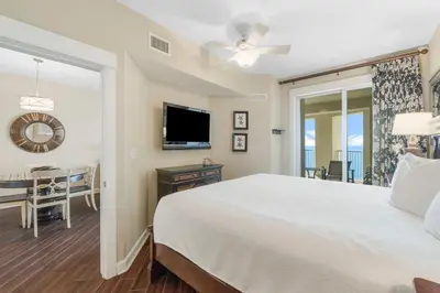 a bedroom with a bed and a television and a table at Grand Panama #1-1903 in Panama City Beach
