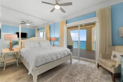 a bedroom with a bed and a balcony with the ocean at Grand Panama #1-2101 in Panama City Beach