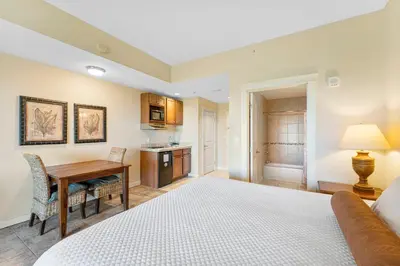 a bedroom with a bed and a desk and a kitchen at Origin #1215 in Panama City Beach