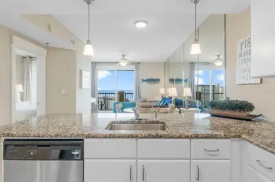 a kitchen with a sink and a living room at Grand Panama #2-0505 in Panama City Beach