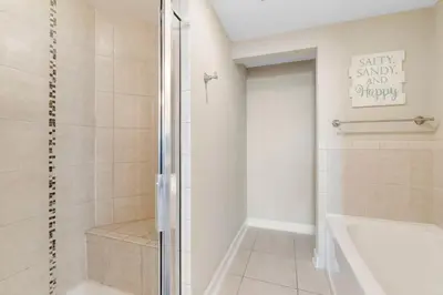 a bathroom with a shower and a tub and a sink at Grand Panama #2-0505 in Panama City Beach