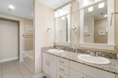a bathroom with two sinks and a mirror and a tub at Grand Panama #2-0505 in Panama City Beach
