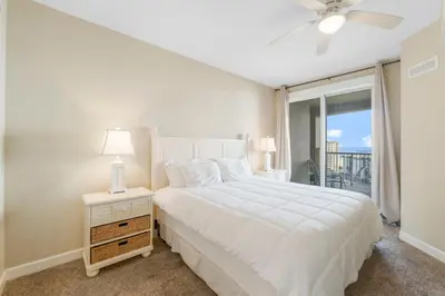 a white bedroom with a bed and a window at Grand Panama #2-0505 in Panama City Beach