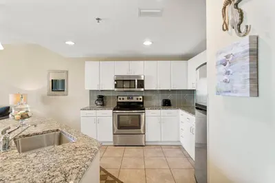 a kitchen with white cabinets and stainless steel appliances at Grand Panama #2-0603 in Panama City Beach