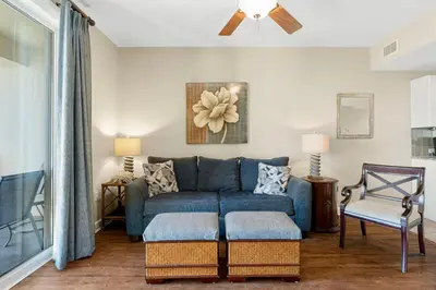 a living room with a blue couch and a chair at Grand Panama #2-0603 in Panama City Beach