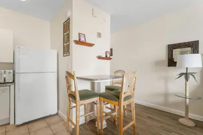 a kitchen with a table and chairs and a refrigerator at Shores Of Panama #1205 in Panama City Beach
