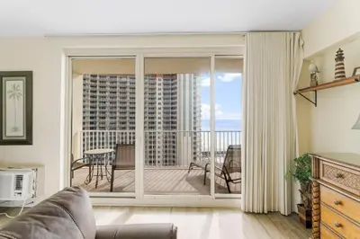 a living room with a sliding glass door to a balcony at Shores Of Panama #1205 in Panama City Beach