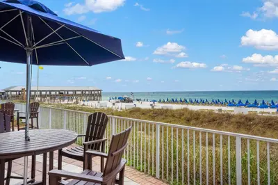a patio with a table and chairs and the beach at Shores Of Panama #1508 in Panama City Beach