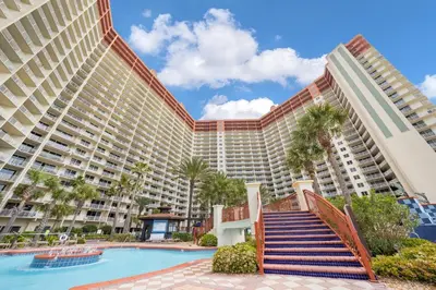 a large resort building with a swimming pool and palm trees at Shores Of Panama #1508 in Panama City Beach