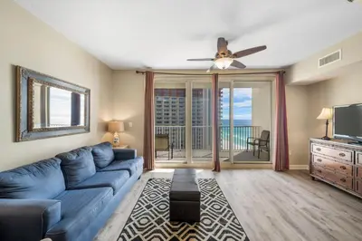 a living room with a blue couch and a ceiling fan at Shores Of Panama #1508 in Panama City Beach