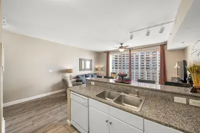 a kitchen with a sink and a living room at Shores Of Panama #1508 in Panama City Beach