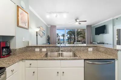 a kitchen with a sink and a view of the ocean at Shores Of Panama #0220 in Panama City Beach