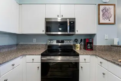 a kitchen with a stove and a microwave at Shores Of Panama #0220 in Panama City Beach
