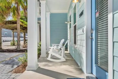 a white chair sitting on the porch of a house at Spectacular 3br 4ba w/ Private Pool, 2 Min Walk to Beach - Sleeps 15! in Panama City Beach