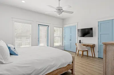 a white bedroom with a bed and a desk at Spectacular 3br 4ba w/ Private Pool, 2 Min Walk to Beach - Sleeps 15! in Panama City Beach