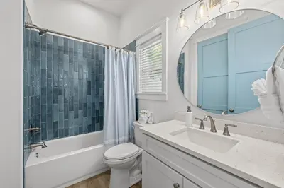 a bathroom with a toilet and a sink and a mirror at Spectacular 3br 4ba w/ Private Pool, 2 Min Walk to Beach - Sleeps 15! in Panama City Beach