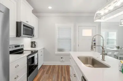 a white kitchen with a sink and a microwave at Laguna Peach: 3BA 2BA retreat for 10! Explore nearby beaches & activities in Panama City Beach