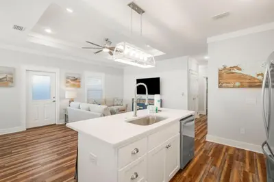 a kitchen with a sink and a living room at Laguna Peach: 3BA 2BA retreat for 10! Explore nearby beaches & activities in Panama City Beach