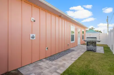 a side view of a building with a grill at Laguna Peach: 3BA 2BA retreat for 10! Explore nearby beaches & activities in Panama City Beach