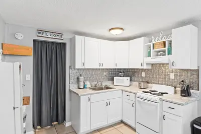 a kitchen with white cabinets and a sink at Fontainebleau Terrace #400 by Book That Condo in Panama City Beach