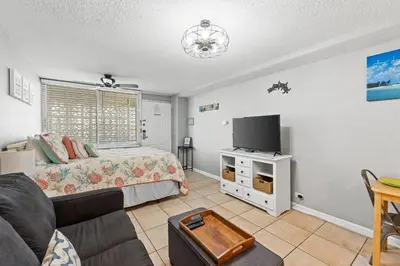 a living room with a bed and a tv at Fontainebleau Terrace #400 by Book That Condo in Panama City Beach