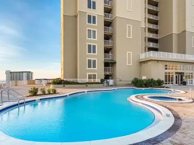 a swimming pool in front of a building at Grand Panama Beach Resort - The Grand #704 in Panama City Beach
