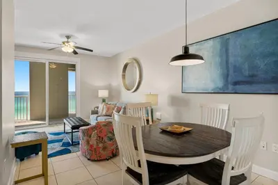 a dining room and living room with a table and chairs at Grand Panama Beach Resort - The Grand #704 in Panama City Beach