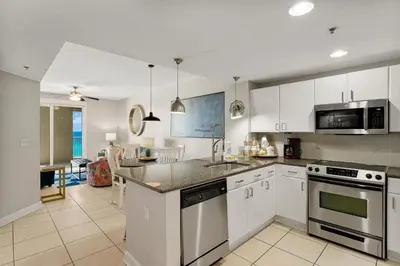 a kitchen with white cabinets and a counter top at Grand Panama Beach Resort - The Grand #704 in Panama City Beach