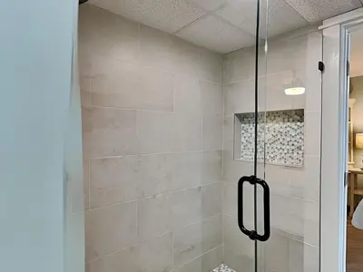a shower with a glass door in a bathroom at Sunbird Beach Resort 1207 West in Panama City Beach