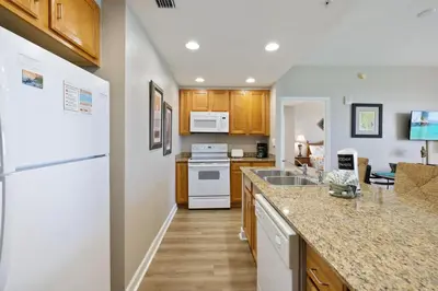 a kitchen with a white refrigerator and a counter top at Beachfront Stunning view 100 ft long swimming pool in Panama City Beach