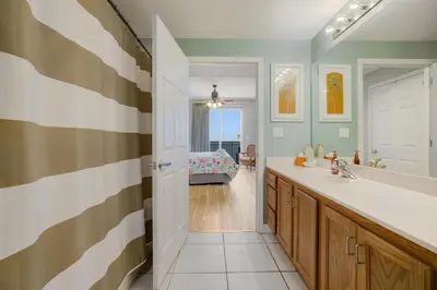 a bathroom with a tub and a sink and a mirror at Beachfront Stunning view 100 ft long swimming pool in Panama City Beach