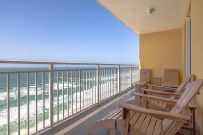 a balcony with chairs looking out at the ocean at Beachfront Stunning view 100 ft long swimming pool in Panama City Beach