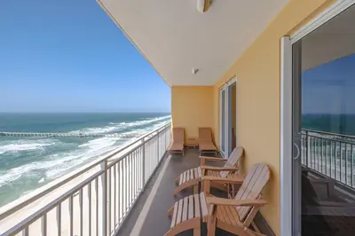 a balcony with chairs and a view of the ocean at Beachfront Stunning view 100 ft long swimming pool in Panama City Beach